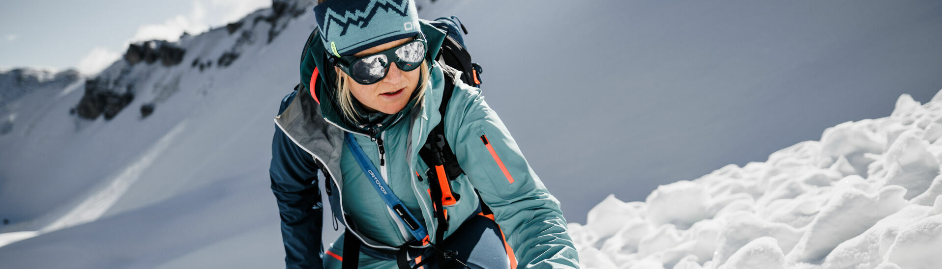 Safety ORTOVOX A woman tests her avalanche transceiver in the wintry mountain landscape at Lake Achensee.