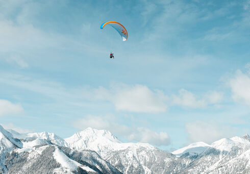 Paragleiten über der Winterlandschaft Winterlandschaft und den Achensee von oben genießen.