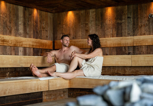 Alle Ausflugsziele Ein Pärchen genießt den Aufguss im Wellnessbereich des Atoll Achensee.