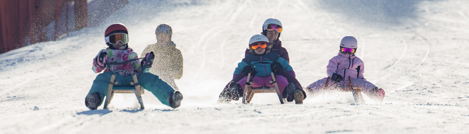 Tobogganing fun in Achenkirch A family races down the toboggan run in Achenkirch in glorious weather. The landscape is covered in snow.