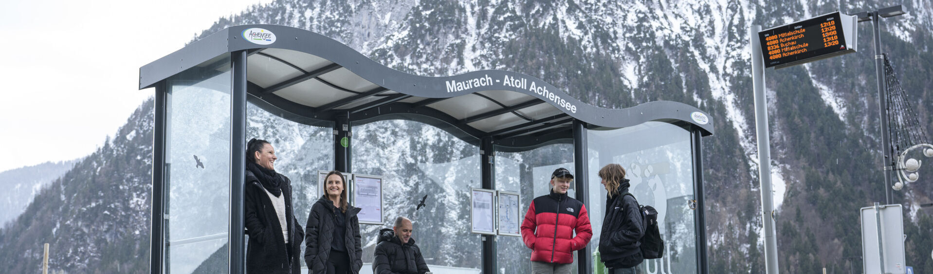 A group of people waiting for the bus in the Achensee atoll in winter.