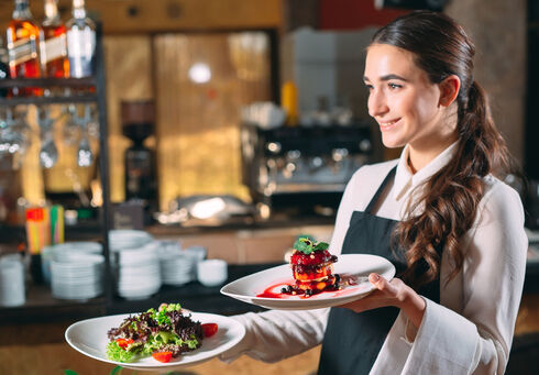 Restaurants & cafés An apprentice serves in a restaurant.
