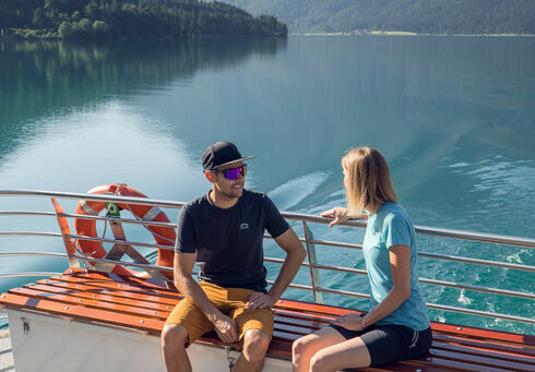 Reduced fare for adults A couple enjoying a boat trip with the Achenseeschifffahrt, enjoying the water and the beautiful natural surroundings.