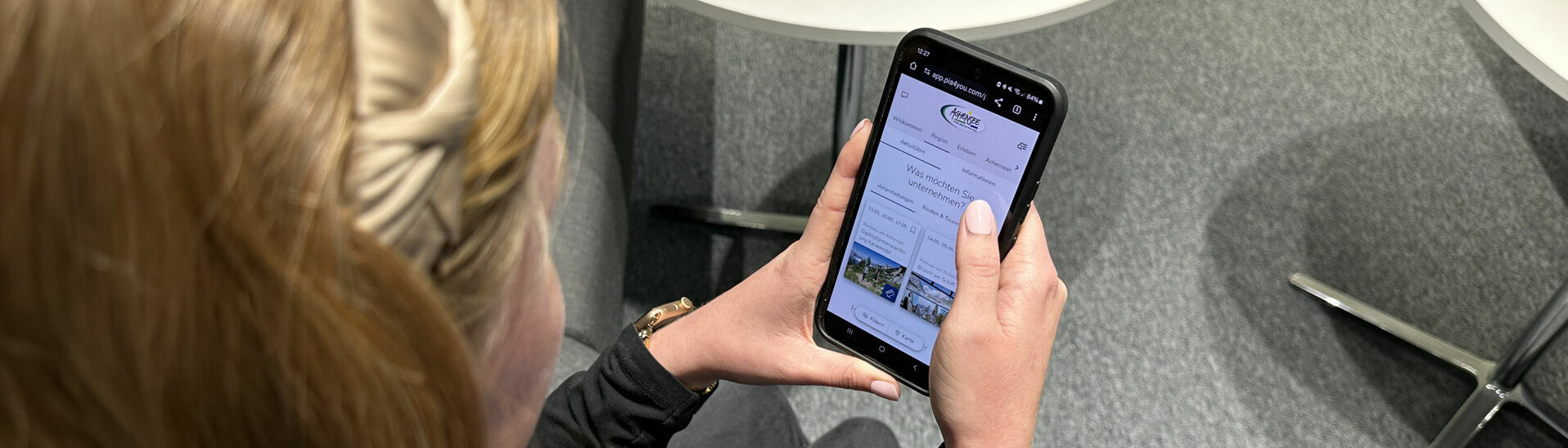 myAchensee, euer Urlaubsbegleiter A woman discovers the digital holiday companion my Achensee on her mobile phone.