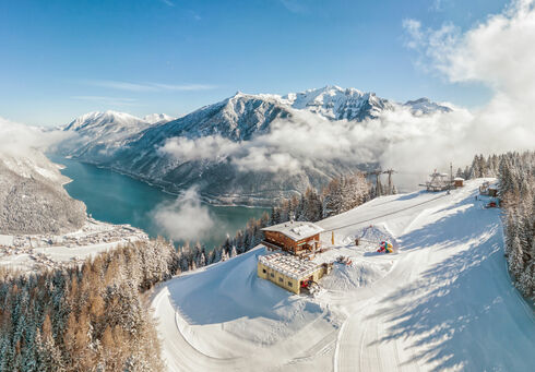 Karwendel-Bergbahn Blick auf die Karwendel-Bergbahn im Winter mit dem Alpengasthaus Karwendel und dem Achensee.