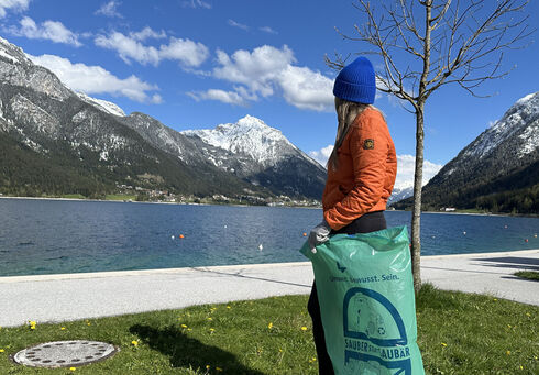 Gemeinsam Müll sammeln Eine junge Frau sammelt Müll an der Seeuferpromenade in Pertisau.