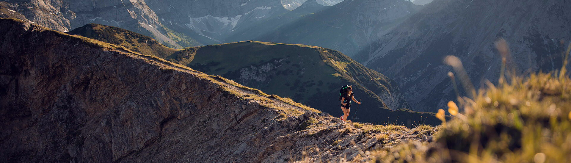 Wandern im Naturpark Karwendel Eine Frau auf dem Weg zum Gipfel vom Sonnjoch bei blauem Himmel.