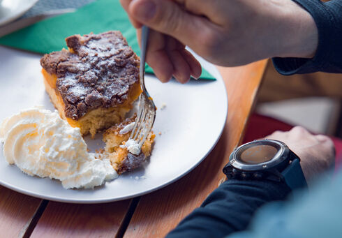 Hütten & Almen Der Einkehrschwung lässt sich bei einem heißen Getränk und leckeren Nachtisch ganz besonders gut genießen. Das Paar macht eine Rast im Waldhäusl in Steinberg am Rofan.