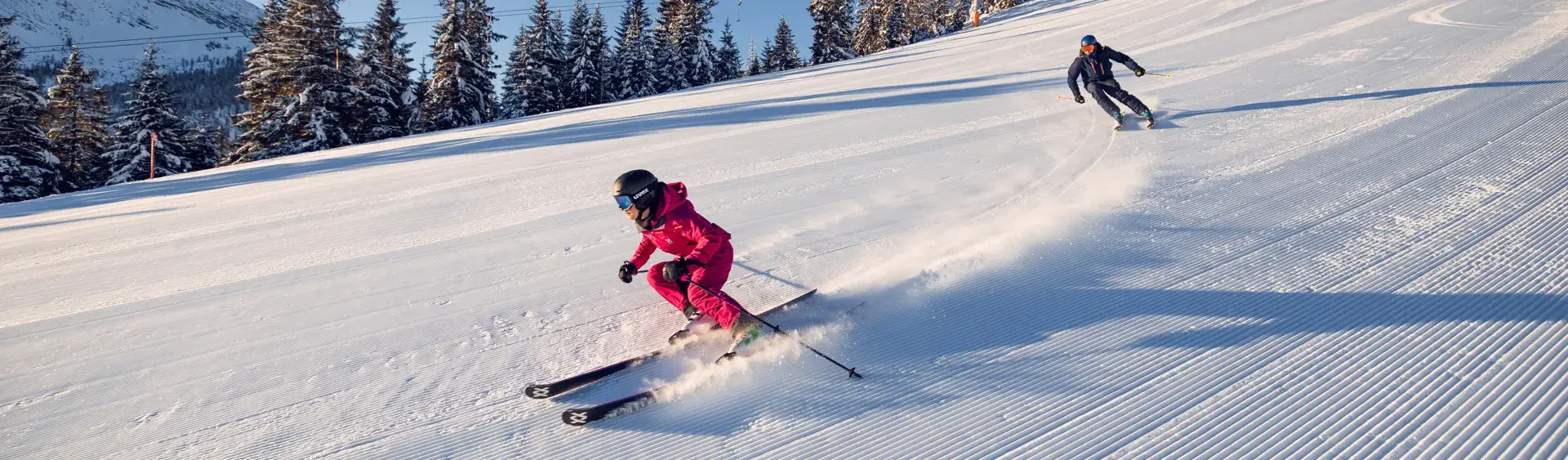 Downhill skiing in Achenkirch am Achensee Two skiers enjoy a day of skiing in brilliant sunshine in the Hochalmlifte Christlum ski area in Achenkirch am Achensee.