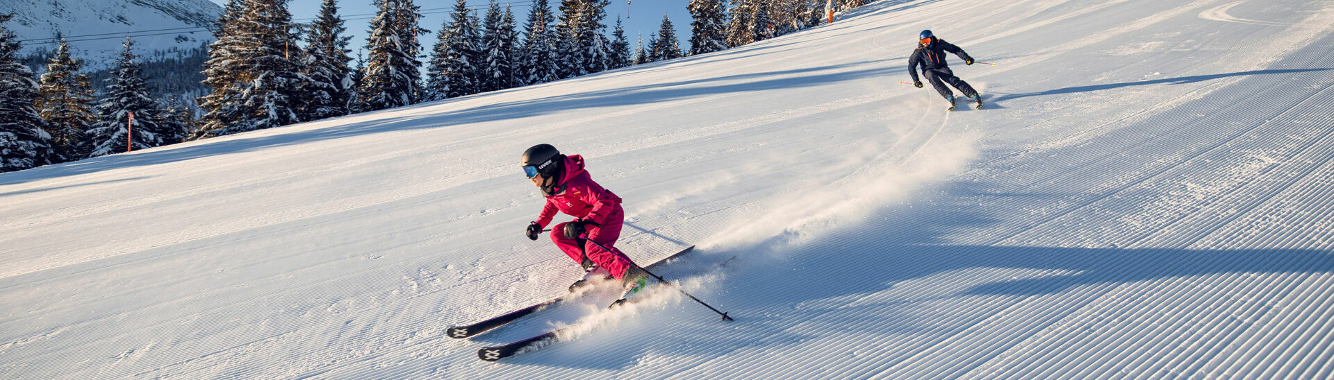Downhill skiing in Achenkirch am Achensee Two skiers enjoy a day of skiing in brilliant sunshine in the Hochalmlifte Christlum ski area in Achenkirch am Achensee.