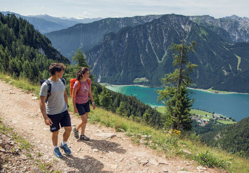 Wanderprogramm im Sommer Ein Pärchen wandert entlang eines Wanderweges im Rofangebirge und genießt die tolle Wiese rundherum.