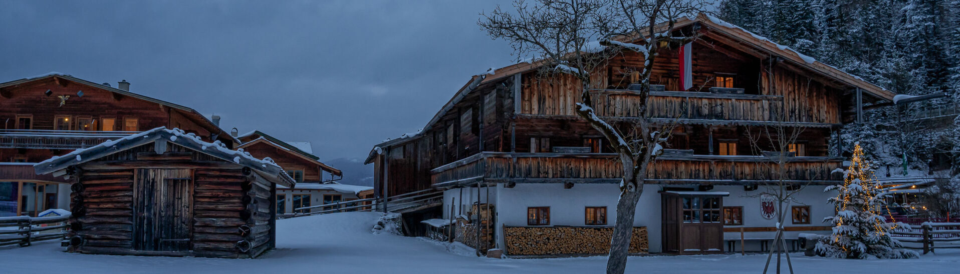 Heimatmuseum Sixenhof im Winter Das Tiroler Heimatmuseum Sixenhof in Achenkirch im Winter. Der Boden ist mit frischem Schnee bedeckt. Im Vordergrund steht ein kleiner Holzschuppen, daneben ein Weihnachtsbaum.