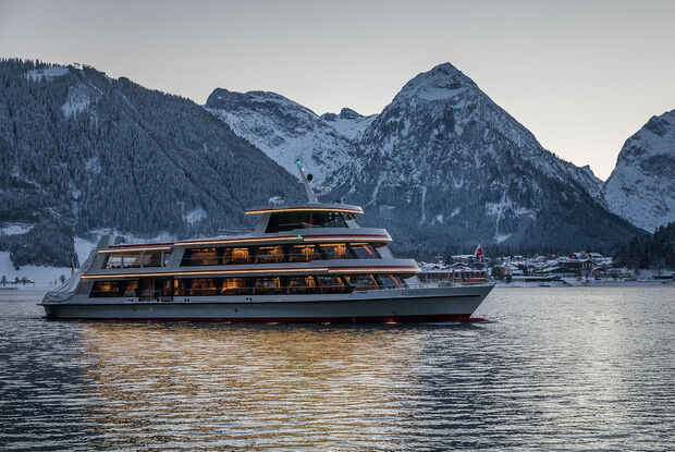 Achenseeschifffahrt in the evening The MS Achensee cruising over Lake Achensee on a winter evening. In the background of this photo is the village of Pertisau and the Karwendel mountains.