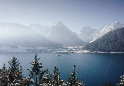 Die Winterlinie der Achenseeschifffahrt Die Achenseeschifffahrt gleitet über den See. Im Hintergrund das verschneite Pertisau am Achensee.