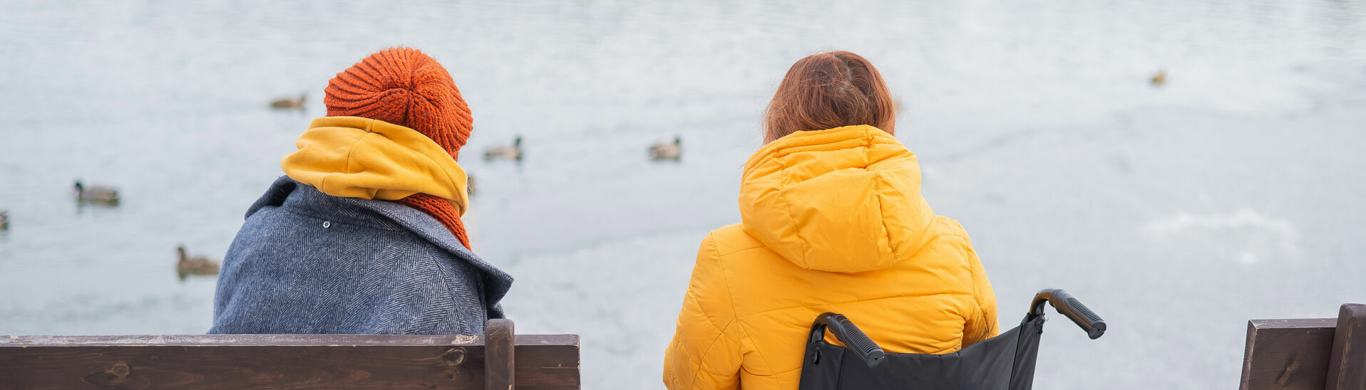 Accessible holidays at Lake Achensee A small family enjoys sitting on the lakeshore, which is partially barrier-free.