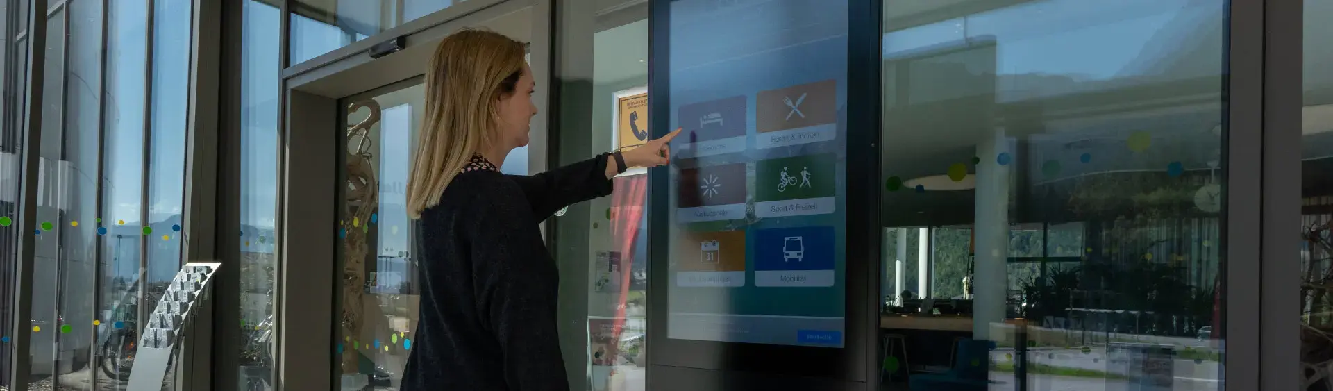 Infoterminals am Achensee Eine Frau informiert sich am Infoterminal im Achensee Atoll über die Region Achensee.