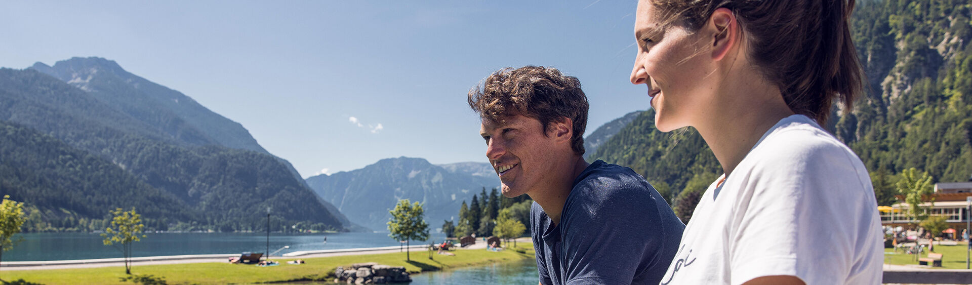 Ein Mann und eine Frau genießen eine kleine Pause beim Badestrand Achensee Nord.