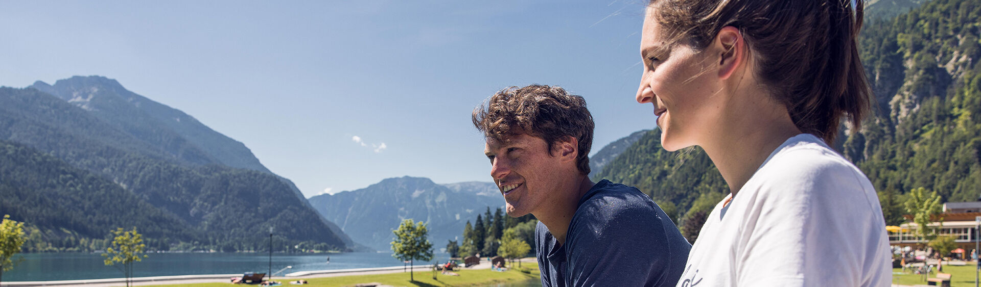 A couple taking a break at the bathing beach Achensee north and enjoying the view.