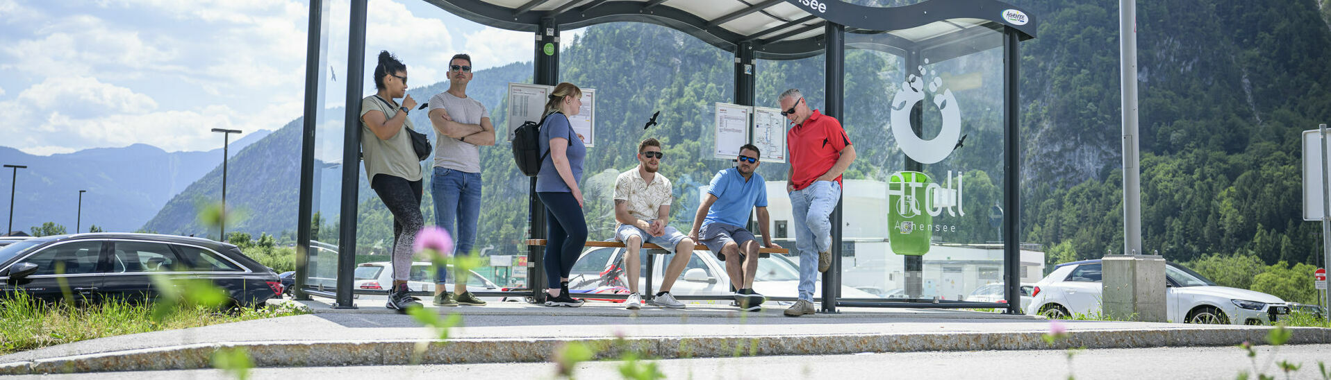 Bushaltestelle beim Atoll Achensee Eine Gruppe Männer und Frauen warten auf den nächsten Bus bei der Haltestelle des Atoll Achensee.