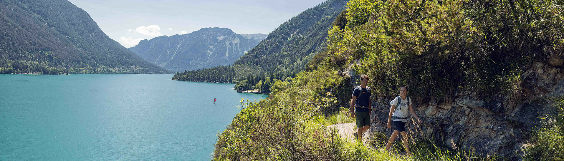 Hiking as a couple on the Gaisalmsteig The Gaisalmsteig travels alongside Lake Achensee from Achenkirch to Pertisau.