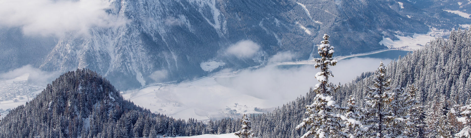 Der Blick vom Rofangebirge auf die verschneite Region Achensee und den Naturpark Karwendel.