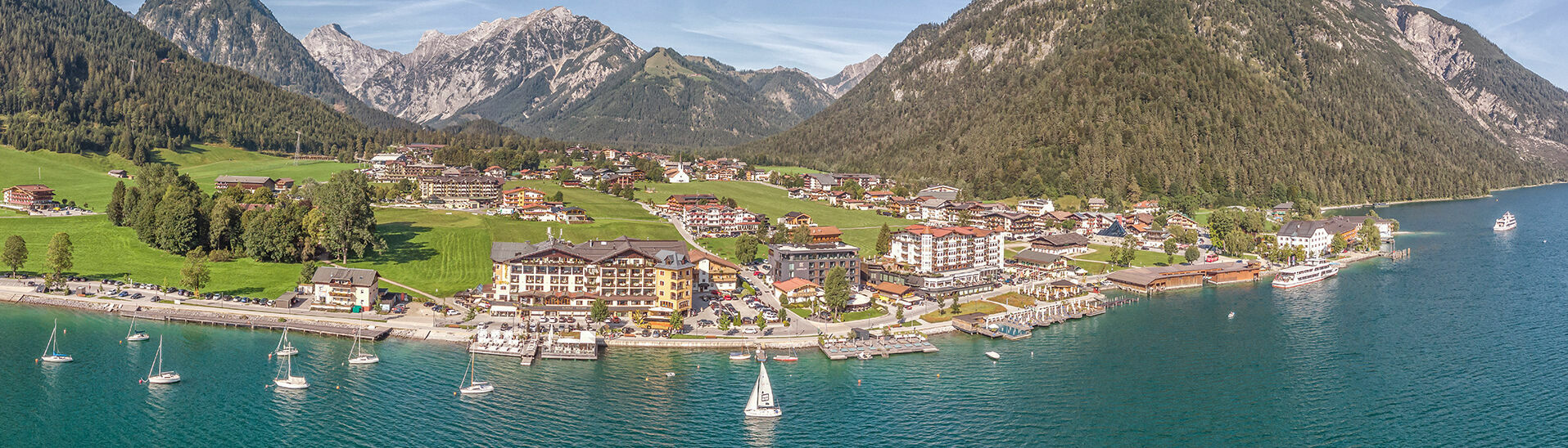 Pertisau am Achensee Pertisau near the Nature Park Karwendel delights with its beautiful landscape. Sailboats can be admired on the shore.